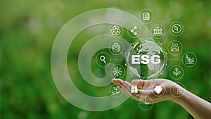 ESG icon concept in the woman hand for environmental, social, and governance by using technology of renewable resources to reduce photo