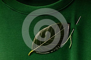 ESG and Sustainability Lifestyle. Environmental Care Concept. Close up of a Green Leaf Embroidered with a Sewing Needle on t-shirt