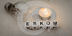 Eskom, electric light bulb and a small candle