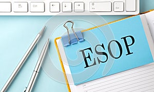 ESOP text on sticker on the blue background with pen and keyboard