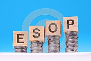 esop - text on wood cubes stack with coins