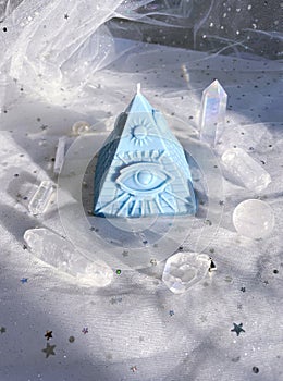 Esoteric candle clairvoyant pyramid surrounded by crystals