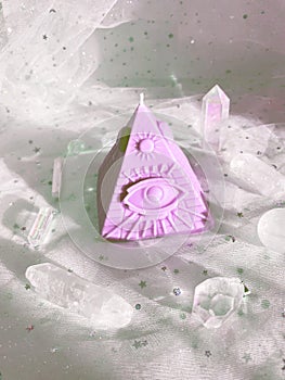 Esoteric candle clairvoyant pyramid surrounded by crystals.