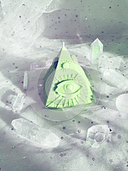 Esoteric candle clairvoyant pyramid surrounded by crystals.