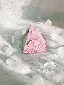 Esoteric candle clairvoyant pyramid surrounded by crystals. photo