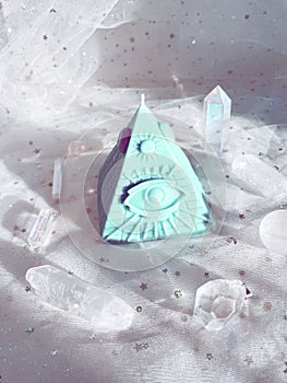 Esoteric candle clairvoyant pyramid surrounded by crystals. photo