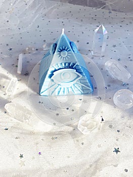 Esoteric candle clairvoyant pyramid surrounded by crystals photo