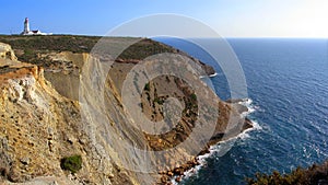 Espichel cape lighthouse sitting on top of a cliff overlooking the Atlantic Ocean. Sesimbra, Portugal