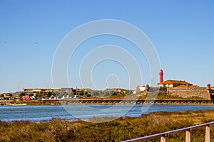 Esposende, Portugal - 10/03/2018: Scenic ocean coast with red lighthouse on background. Sunny day at sea shore in Portugal. photo