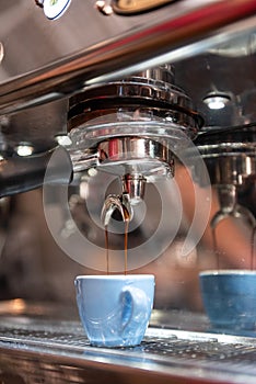 Espresso being made and put into a blue demitasse photo