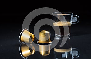 Espresso capsules and coffee cup on black background, Closeup view with details