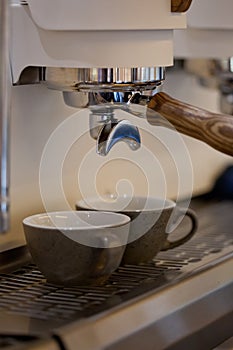Espresso ceramic cups in modern professional coffee machine