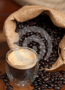 Espresso and Coffee Beans in burlap bag spilling on table