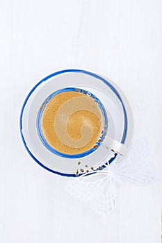 Espresso coffee in blue trim white cup and saucer