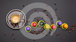 Espresso coffee cup, beans and capsules, pods, on black color background