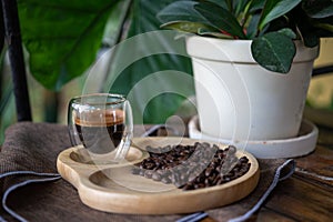 Espresso coffee cup on wood plate with coffee beans