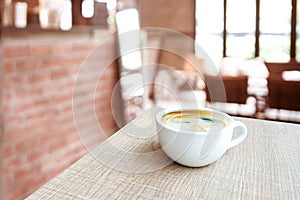 Espresso Coffee cup on wood table in cafe with blur coffee shop