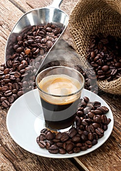 Espresso coffee in glass cup with coffee beans.