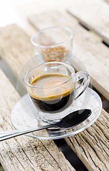 Espresso coffee in glass cup on wooden table