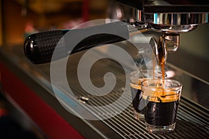 Espresso coffee pouring into glass shot