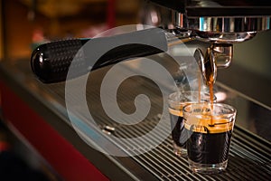 Espresso coffee pouring into glass shot photo