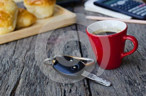 Espresso coffee red cup and Car key on wooden table backgrounds