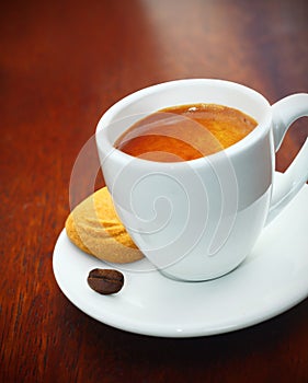 Espresso coffee served with a biscuit