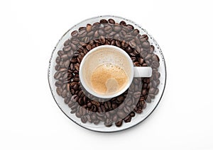 Espresso coffee in small cup and fresh raw beans on saucer on white background