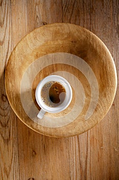 Espresso coffee in thick white cup on old wood