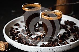 Espresso coffee in two glasses. Dark background. Dark style