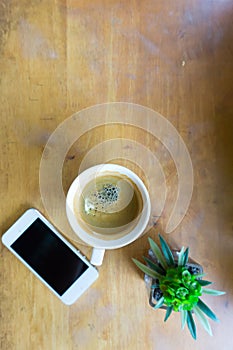 Espresso coffee in white cup with smartphone with copy space