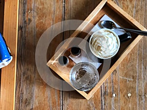 Espresso con panna in Black and white cup on wooden table with natural light.