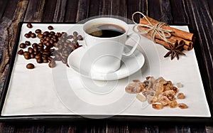 Espresso cup, coffee beans, sugar and cinnamon with anise on a white background