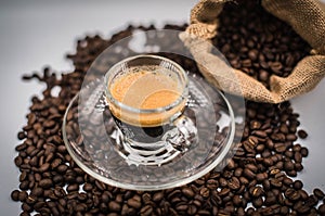 The espresso is housed in a pile of roasted Arabica coffee beans