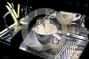 Espresso making with milk in cafeteria. Coffeemaking by barista in reataurant.