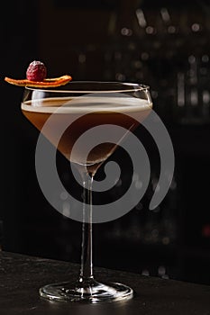 Espresso Martini Cocktail based on coffee, liqueur and vodka. Served with orange chips and raspberry. Space for text