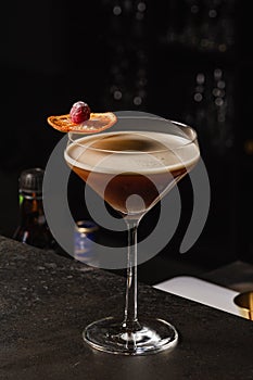 Espresso Martini Cocktail based on coffee, liqueur and vodka. Served with orange chips and raspberry. Space for text