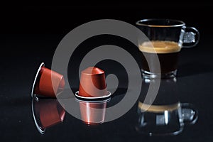 Espresso pods and coffee cup on black background, Closeup view with details