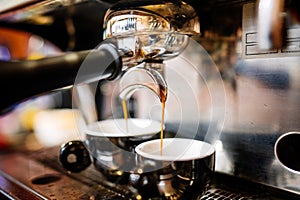 Espresso pouring from coffee machine into cups. Prof