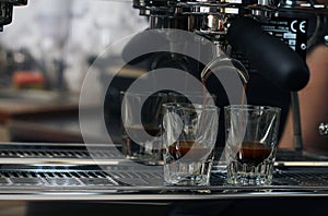 Espresso pouring into two shot glasses