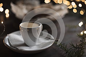 Espresso surrounded by New Year`s lights and pine branches. Food dark background. Christmas lunch in a cafe