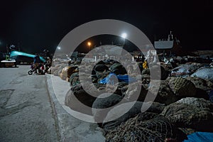 Essaouira port in Morocco. Local People are sitting near the piles of fishing nets at night