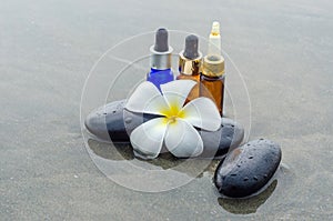 Essence oil, White frangipani and zen stone on water