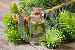 Essential aromatic oil spruce closeup on a wooden