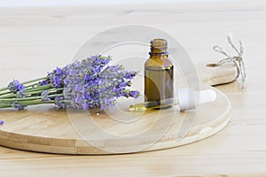 Essential lavender oil in the bottle with dropper on wooden desk. Horizontal close-up