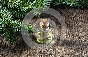 Essential oil bottle with fresh fir twigs, with copy space