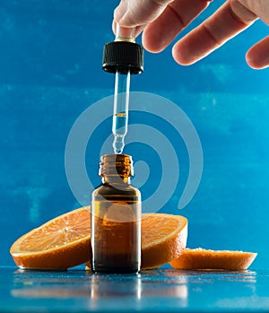 Essential oil bottle with orange slices and dropper