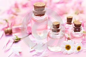 Essential oil bottles on medicinal flowers and herbs background