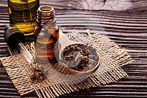 Essential oil of cloves on a wooden rustic background