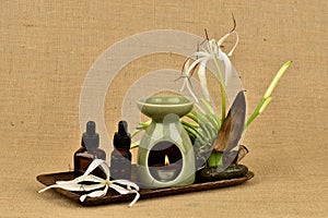 Essential oil Crinum lily and oil burner burned on a  Brown hemp sack background.